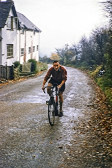Man cycling uphill, cycling club ride in Kent, England, UK 1956