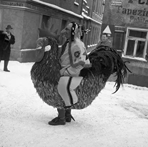 Man dressed as a cock walks through the snow-covered streets of Freiburg