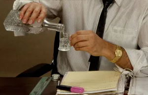 Man drinks liquor in the office