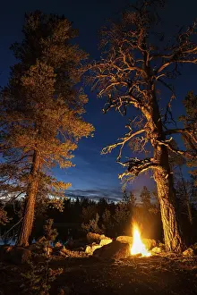Man in the evening at a bivouac with campfire