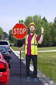 Man flagman holding a stop sign to halt traffic