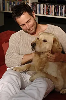 Man with Golden Retriever sitting on a sofa