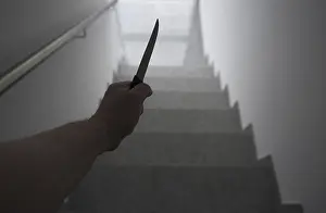 Man Holding a Knife in the Staircase with a Window Light in Switzerland