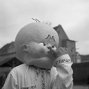 Man with huge baby mask, carnival