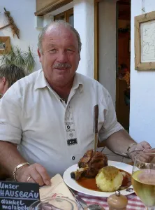 Man with knuckle of pork and dumplings
