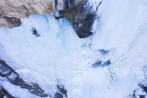 Man is leading on Ice. Ice Climbing on Frozen Waterfall
