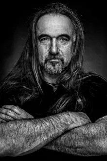Man with long hair and hand with folded arms