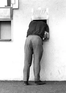 Man looking through a small window of a ticket sale