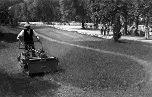 Man mowing lawn, historic picture from about 1920