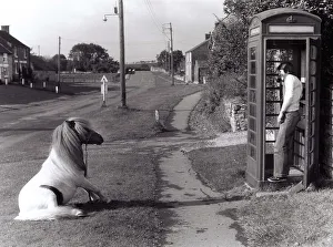 Man on the phone in a payphone box