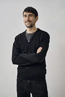 A man is posing confidently with arms crossed