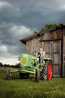 Man with a prosthetic leg driving a vintage tractor