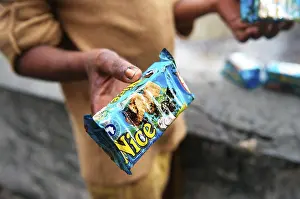 Man showing oil soaked biscuit packets due to container ship chitra colliding in sea Bombay Mumbai
