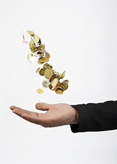 A man throws coins into the air and then catches them