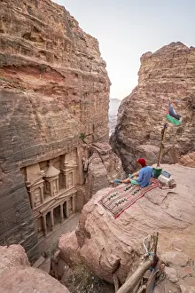 Man, tourist looks from above into the gorge Siq