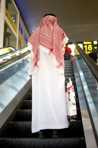 Framed Print : Man in traditional white Arabian dressed on automatic ladder Framed Print : Man in traditional white Arabian dressed on automatic ladder