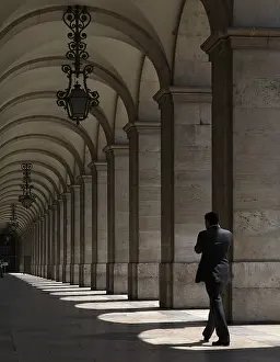 Man walking through an arched corridor