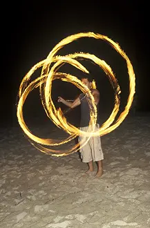 A man waves burning torches on the beach of Coral Beach Resort on the island of Ko Lanta