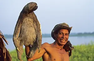 A man who runs a small private zoo near Iquitos on the Amazon shows a sloth