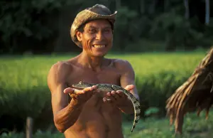 A man who runs a small private zoo near Iquitos on the Amazon shows a young caiman