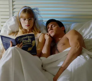 Man and woman in bed Woman reading newspaper
