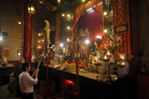 Man and woman praying with incense sticks