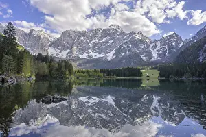 The Mangart mountain range reflected in Lake Fusine