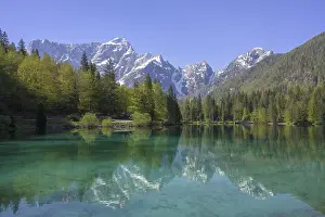 Mangart mountain range reflected in the lower Fusine Lake