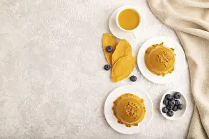Mango and passion fruit jelly with blueberry on gray concrete background and linen textile