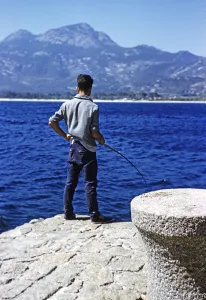 Mann mit Angelrute am Kai, Calvi, Korsika, Frankreich, Ende der 1950er Jahre