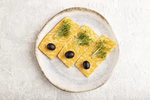 Marble cheese with olives and watercress microgreen on gray concrete background