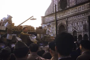 Market trader selling to a crowd on the street, next to the cathedral, Florence, Italy, 1957, Europe