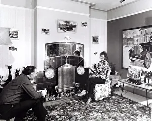 Married couple sitting in apartment with car decoration