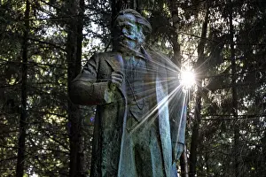 Marx monument in the sunlit forest of Grutas Park in Druskininkai