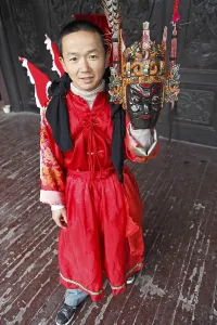 Mask dancer in Ci-Yun Temple holding a traditional mask