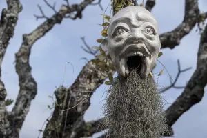 A mask hanging on a tree, at the Wat Rong Khun temple or The White Wat