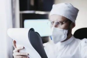 Medical professional holding and examining documents
