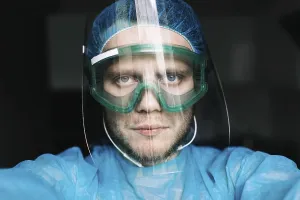 A medical professional wearing protective gear including a face shield and goggles