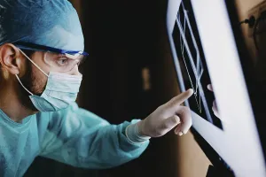 A medical staff member focusing on a screen displaying data in a protected setting