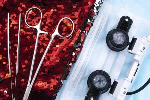 Medical tools and goggles placed on sequins alongside a surgical mask