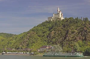 Medieval castle on a mountain, river and passenger ship