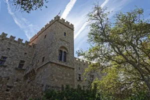 Medieval castle with stone towers under a clear sky and surrounded by trees