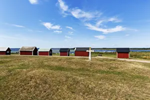 Medieval stone cross and characteristic red fishing huts