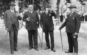 Four men with glasses of beer and walking sticks