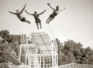 Three men jumping in a swimming pool