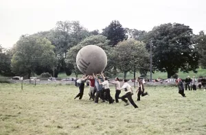 Men playing a game with a giant Daily Mail push ball on a field, Northern Ireland, late 1950s, circa 1960s