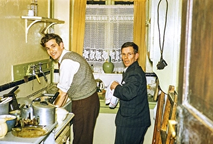 Two men washing dishes in the kitchen of a house, Great Britain 1956