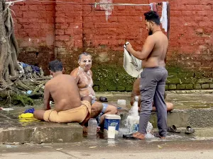 Men washing themselves with water on the roadside in a relaxed atmosphere