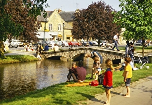 Menschen am Flussufer sitzend, River Windrush, Bourton on the Water, Gloucestershire, England, UK Mai 1973