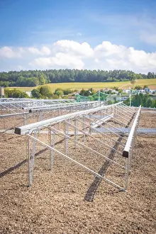Metal structures for solar panels in an open field under a blue sky